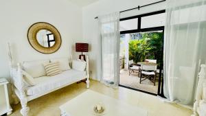 a living room with a white couch and a mirror at Nyumba Nyekundu in Watamu +46 photos