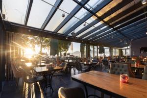 a restaurant with tables and chairs and windows at Hotel Schlossblick Chiemsee in Prien am Chiemsee