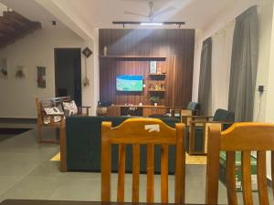 a living room with a table and chairs and a dining room at Coorg Family Villa in Gonikoppal