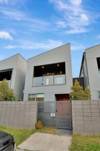 a gray building with a garage in front of it at Stylish 3-Bedroom Townhouse Near Shops & Parks in Point Cook