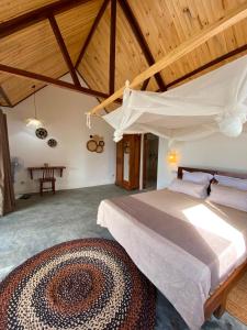a bedroom with a large bed and a wooden ceiling at Ankavia Lodge in Sainte Marie