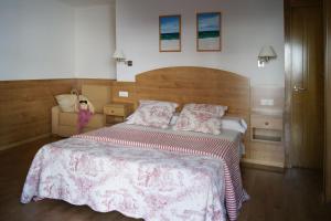 a bedroom with a large bed with a wooden headboard at Hostal Casa Isabel in Portonovo