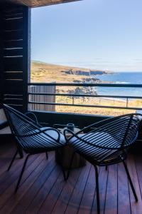 a hammock on a deck with a view of the ocean at Wood Hôtel & Spa in Saint-Gilles-les-Bains