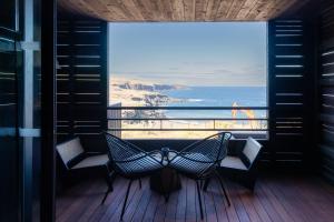 a balcony with two chairs and a view of the ocean at Wood Hôtel & Spa in Saint-Gilles-les-Bains