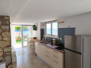 a kitchen with a stainless steel refrigerator and a counter at Elina Apartments in Parga