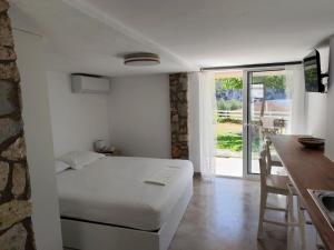 a bedroom with a bed and a kitchen with a table at Elina Apartments in Parga