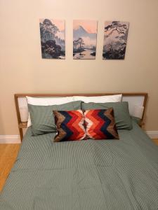 a bed with two pillows and four pictures on the wall at Yokomokko House in Bridgewater