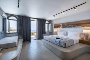 a large bedroom with a large bed and a couch at Xenones Filotera in Imerovigli