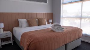 a bedroom with a large bed with towels on it at Home Abroad in Ascot Park