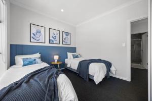 two beds in a room with blue and white at Home Abroad in Ascot Park