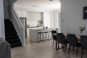 a kitchen and dining room with a table and chairs at Home Abroad in Ascot Park