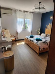 a bedroom with a bed and a chair and windows at la casa bella vista in Enval