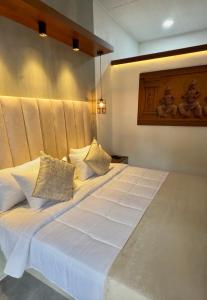 a large bed with white sheets and pillows at Villa Dominikku in Negombo +34 photos