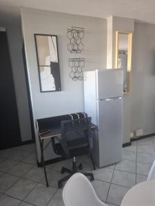 a office with a chair and a refrigerator at Blouberg Beach Escape in Cape Town