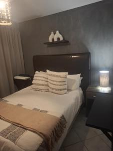 a bedroom with a bed with white sheets and pillows at Blouberg Beach Escape in Cape Town