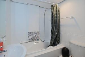 a bathroom with a shower and a sink and a toilet at Blouberg Beach Escape in Cape Town +8 photos