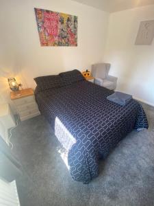 a bedroom with a large bed and a chair at 5 Star Large Double Room in Hull with Free Parking & WIFI in Anlaby