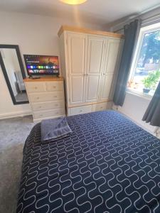 a bedroom with a bed and a dresser and a television at 5 Star Large Double Room in Hull with Free Parking & WIFI in Anlaby