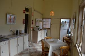 cocina con mesa, sillas y nevera en Old Parkes Convent en Parkes