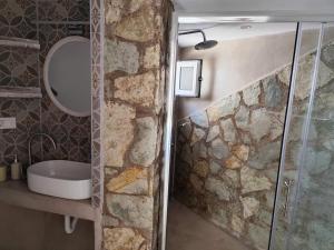 a bathroom with a stone wall and a shower at Elina Apartments in Parga +77 photos