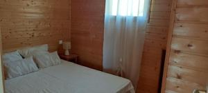 a bedroom with a white bed and a window at Chalet ondalis in Le Malzieu-Ville +1 photo