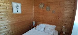 a bedroom with a wooden wall with a bed at Chalet ondalis in Le Malzieu-Ville