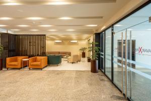 a lobby with orange chairs and a waiting room at Avari Xpress Gilgit in Gilgit