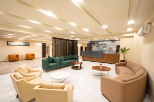 a lobby with couches and chairs and a tv at Avari Xpress Gilgit in Gilgit