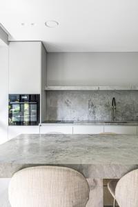 a kitchen with a large marble table and two chairs at Refined luxury apartment surrounded by forest in Vilnius +43 photos