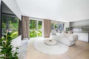 a living room with a white couch and a table at Refined luxury apartment surrounded by forest in Vilnius