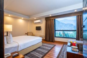 a hotel room with a bed and a large window at Avari Xpress Gilgit in Gilgit
