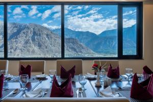 a dining room with a table with a view of mountains at Avari Xpress Gilgit in Gilgit