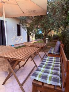 a picnic table and bench under an umbrella at B&B Marku in Dëllinjë