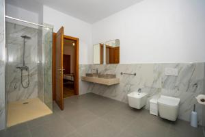 a bathroom with two toilets and a shower and a sink at Guesthouse Véni i Gjyshit in Shkodër