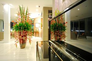 a lobby with two large vases with plants in it at Kasemsarn Hotel Chanthaburi in Chanthaburi