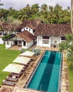 an aerial view of a villa with a swimming pool and umbrellas at udesh hotel in Minuwangoda