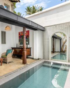 an indoor swimming pool in a house with a piano at udesh hotel in Minuwangoda