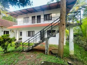 a house with a staircase in front of it at Sea Mist Beach Villas Alleppey in Alleppey
