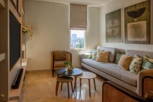 a living room with a couch and a table at Dago Suite 3BR Luxury Apartment in Bandung