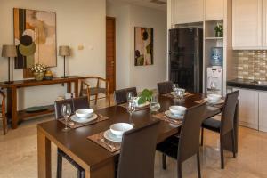 a dining room with a table and chairs and a kitchen at Dago Suite 3BR Luxury Apartment in Bandung