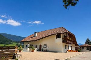 a white house with a brown roof at Riolina Suite in Mühlbach