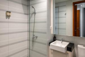 a bathroom with a sink and a glass shower at Dago Suite 3BR Luxury Apartment in Bandung +21 photos