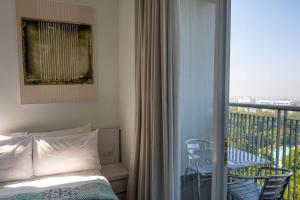 a bedroom with a bed and a balcony at Dago Suite 3BR Luxury Apartment in Bandung