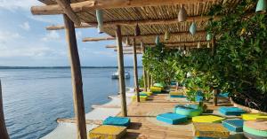 a row of chairs on a beach next to the water at Nyumba Nyekundu in Watamu