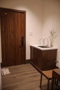 a bathroom with a sink and a wooden door at Shine Home in Hue