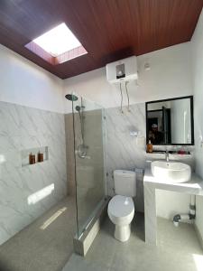 a bathroom with a toilet and a sink and a shower at Penida Cabins in Nusa Penida