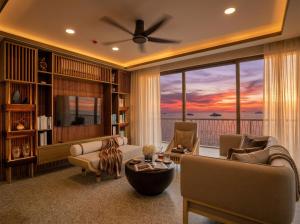a living room with a view of the ocean at Riahi Villas by Swiss-Belhotel, Nirup Island in Belakangpandang