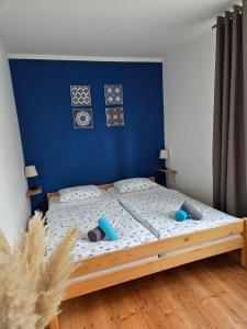 a bedroom with a bed with a blue wall at Apartmán Wake u aquaparku in Česká Lípa +30 photos