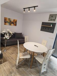 a table and chairs in a living room with a couch at Terra Residence Beiuș in Beiuş