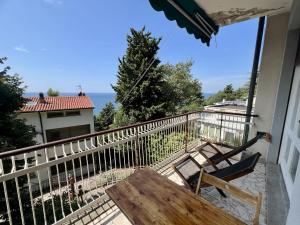 a balcony with two chairs and a wooden table at Sea Breeze - Barcola - Trieste Reception in Trieste